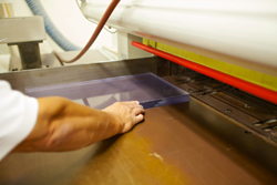 Closeup of worker cutting plastic sheet